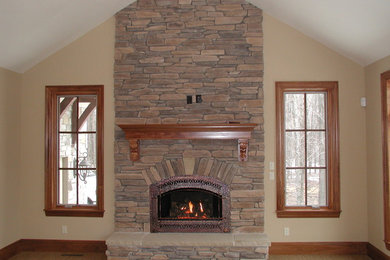 Example of a large open concept carpeted family room design in Cleveland with beige walls, a standard fireplace and a stone fireplace
