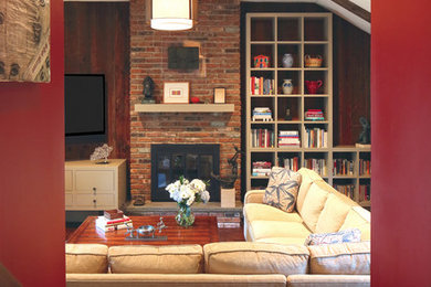 Foto de sala de estar cerrada tradicional renovada de tamaño medio con paredes rojas, suelo de madera oscura, todas las chimeneas, marco de chimenea de ladrillo y televisor colgado en la pared