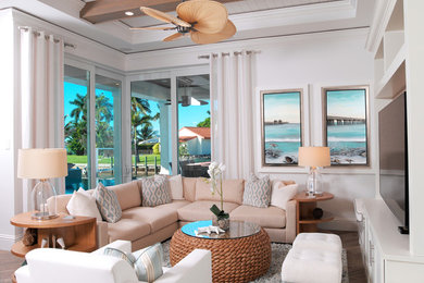 マイアミにあるラグジュアリーな巨大なビーチスタイルのおしゃれなオープンリビング (ホームバー、白い壁、無垢フローリング、暖炉なし、壁掛け型テレビ) の写真