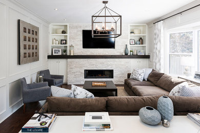 Inspiration for a mid-sized transitional open concept dark wood floor family room remodel in Toronto with white walls, a standard fireplace, a stone fireplace and a wall-mounted tv
