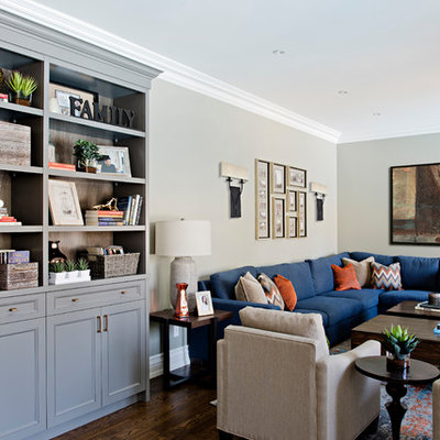 Family room - mid-sized transitional medium tone wood floor and brown floor family room idea in Toronto with gray walls, a standard fireplace, a wood fireplace surround and a wall-mounted tv