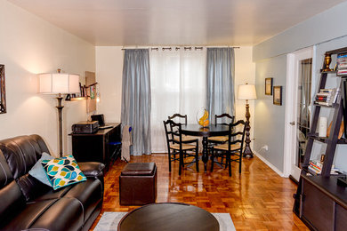Imagen de sala de estar abierta bohemia pequeña con paredes azules, suelo de madera clara y suelo marrón