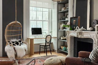 Imagen de sala de estar ecléctica con paredes grises, suelo de madera en tonos medios, todas las chimeneas y suelo marrón