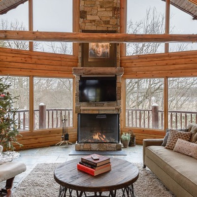 Inspiration for a rustic family room remodel in Minneapolis with a standard fireplace, a stone fireplace and a wall-mounted tv
