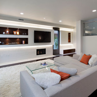 Family room - large contemporary open concept dark wood floor family room idea in Los Angeles with white walls, a standard fireplace, a tile fireplace and a wall-mounted tv