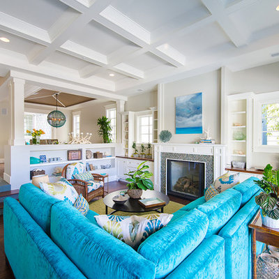 Large beach style open concept dark wood floor and brown floor family room photo in Los Angeles with a standard fireplace, a tile fireplace, no tv and gray walls