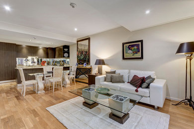 Diseño de sala de estar abierta contemporánea de tamaño medio con paredes blancas y suelo de madera en tonos medios
