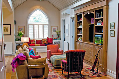 Foto de sala de estar abierta clásica de tamaño medio con paredes beige, suelo de madera en tonos medios y pared multimedia