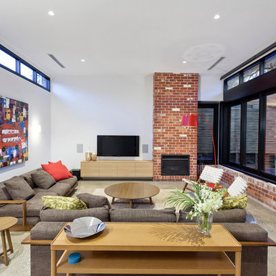 Example of a trendy family room design in Melbourne with white walls, a standard fireplace and a wall-mounted tv