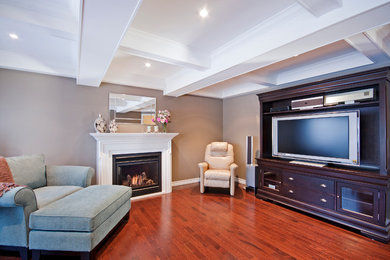 Example of a mid-sized trendy open concept medium tone wood floor family room design in Toronto with a music area, beige walls, a standard fireplace, a wood fireplace surround and a media wall