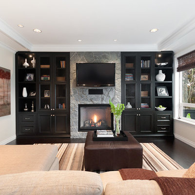 Family room - traditional family room idea in Vancouver with a standard fireplace, a stone fireplace and a wall-mounted tv