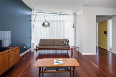 Ejemplo de sala de estar abierta ecléctica de tamaño medio con suelo de madera oscura