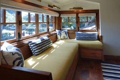 Foto de sala de estar abierta marinera de tamaño medio sin chimenea y televisor con paredes grises, suelo de madera en tonos medios y suelo marrón