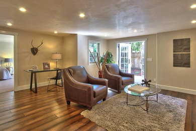 Ejemplo de sala de estar de estilo americano sin televisor con paredes beige y suelo de madera oscura