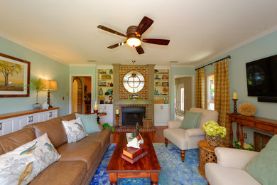 Family room - mid-sized transitional enclosed medium tone wood floor family room idea in Tampa with blue walls, a standard fireplace, a wood fireplace surround and a wall-mounted tv