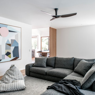 Trendy open concept medium tone wood floor and brown floor family room photo in Sunshine Coast with white walls