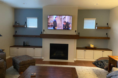 Example of a mid-sized farmhouse dark wood floor and brown floor family room design in Denver with gray walls, a standard fireplace and a tile fireplace