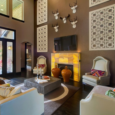 Inspiration for an eclectic dark wood floor family room remodel in Dallas with brown walls, a standard fireplace and a wall-mounted tv