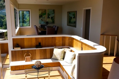 Ejemplo de sala de estar abierta actual grande sin chimenea y televisor con paredes grises, suelo de madera clara y suelo beige