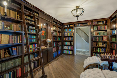 Aménagement d'une salle de séjour classique fermée avec une bibliothèque ou un coin lecture, un sol en bois brun, aucune cheminée et un sol marron.