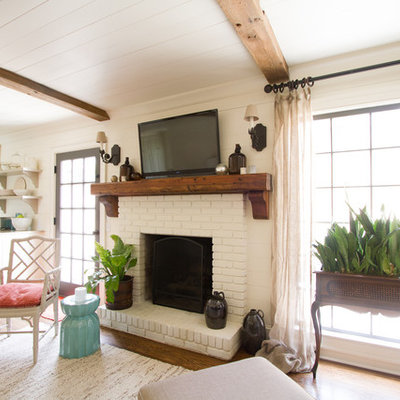 Family room - traditional open concept medium tone wood floor family room idea in Atlanta with beige walls, a standard fireplace, a brick fireplace and a wall-mounted tv