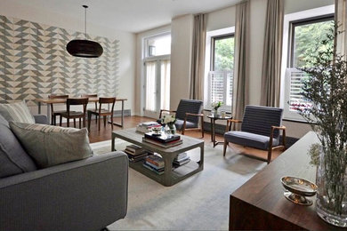 Family room - mid-sized transitional loft-style medium tone wood floor family room idea in New York with a wall-mounted tv and white walls