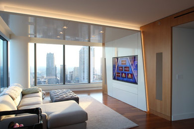 Diseño de sala de estar abierta contemporánea de tamaño medio sin chimenea con suelo de madera oscura, pared multimedia y paredes beige