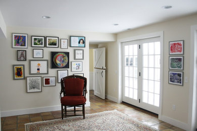 Mittelgroßer, Abgetrennter Klassischer Hobbyraum ohne Kamin mit beiger Wandfarbe, Terrakottaboden und Multimediawand in New York