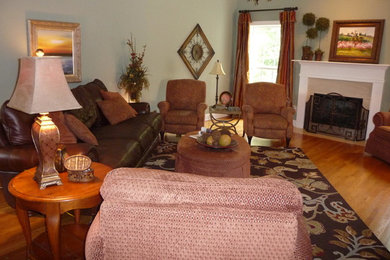 На фото: изолированная гостиная комната среднего размера в классическом стиле с зелеными стенами, светлым паркетным полом, стандартным камином и фасадом камина из дерева без телевизора с