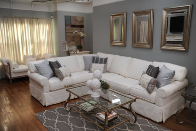 Imagen de sala de estar abierta clásica renovada grande sin chimenea y televisor con paredes grises, suelo de madera en tonos medios y suelo marrón