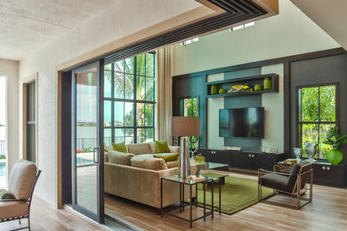 Modelo de sala de estar abierta actual grande sin chimenea con paredes beige, suelo de bambú y televisor colgado en la pared