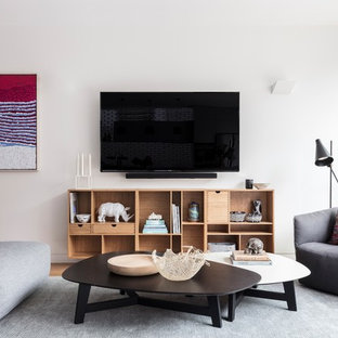 Contemporary open concept family room in Sydney with white walls, light hardwood floors and a wall-mounted tv.