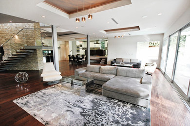 Ispirazione per un ampio soggiorno contemporaneo aperto con pareti bianche, pavimento in legno massello medio e TV a parete