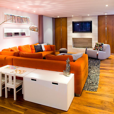 Large trendy open concept medium tone wood floor family room photo in Vancouver with white walls, a wall-mounted tv and a stone fireplace