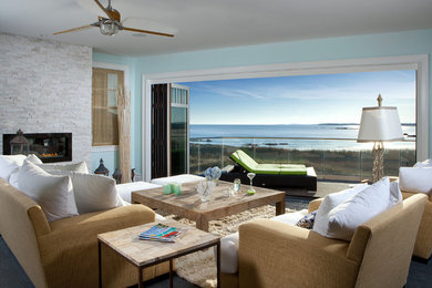 Diseño de sala de estar abierta actual grande con paredes azules, suelo de madera en tonos medios y marco de chimenea de piedra