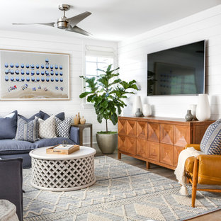 Mid-sized beach style open concept light wood floor and beige floor family room photo in Orange County with white walls, a wall-mounted tv and no fireplace