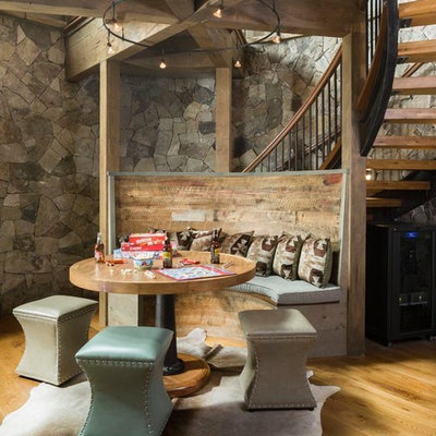 Example of a mid-sized mountain style open concept medium tone wood floor, brown floor and exposed beam family room design in Denver with gray walls