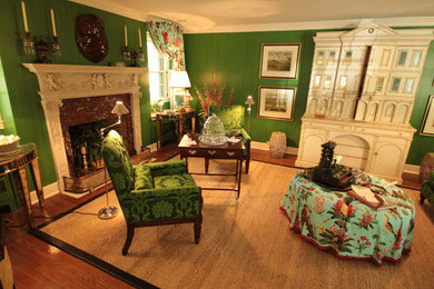 Foto de sala de estar cerrada tropical sin televisor con paredes verdes, suelo de madera en tonos medios y todas las chimeneas