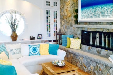 Foto de sala de estar abierta marinera de tamaño medio con paredes blancas, suelo de madera clara, chimenea lineal, marco de chimenea de piedra y televisor colgado en la pared