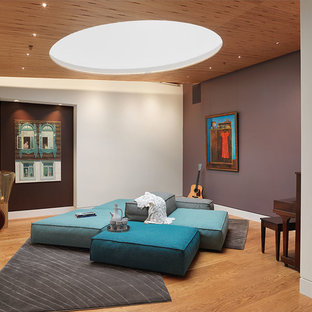 Ispirazione per un soggiorno design aperto con sala della musica, pareti viola, pavimento in legno massello medio, nessun camino e nessuna TV