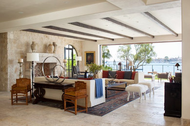 Example of a trendy limestone floor family room design in Orange County with a stone fireplace