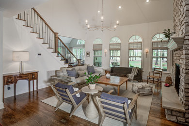 Inspiration for a large transitional open concept dark wood floor and brown floor family room remodel in Raleigh with beige walls, a standard fireplace, a stone fireplace and no tv