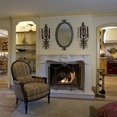 Example of a mid-sized ornate open concept light wood floor and brown floor family room design in Orange County with a standard fireplace, yellow walls, a media wall and a plaster fireplace