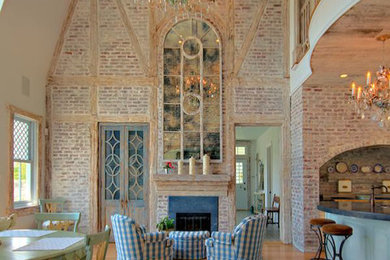 Imagen de sala de estar abierta de estilo de casa de campo grande sin televisor con paredes multicolor y marco de chimenea de piedra