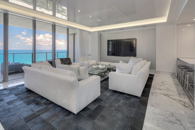 Imagen de sala de estar abierta actual grande sin chimenea con suelo de mármol, televisor colgado en la pared, paredes grises y suelo gris