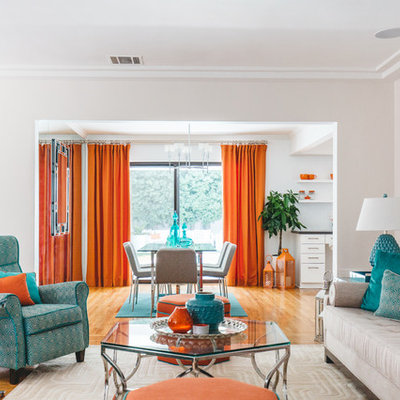 Example of an eclectic enclosed medium tone wood floor and orange floor game room design in Los Angeles with white walls