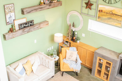 Ejemplo de sala de estar abierta moderna con paredes verdes, suelo de cemento, chimenea de doble cara, marco de chimenea de yeso, pared multimedia y suelo verde