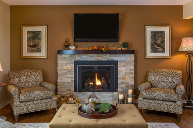 Ejemplo de sala de estar clásica de tamaño medio con suelo de madera en tonos medios, todas las chimeneas, marco de chimenea de piedra y televisor colgado en la pared