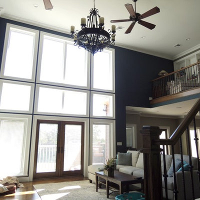 Example of a large arts and crafts open concept dark wood floor and brown floor family room design in New York with blue walls, no fireplace and a wall-mounted tv