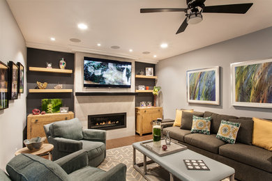 Modelo de sala de estar abierta clásica renovada pequeña con paredes grises, suelo de madera oscura, chimenea lineal, marco de chimenea de baldosas y/o azulejos y televisor colgado en la pared